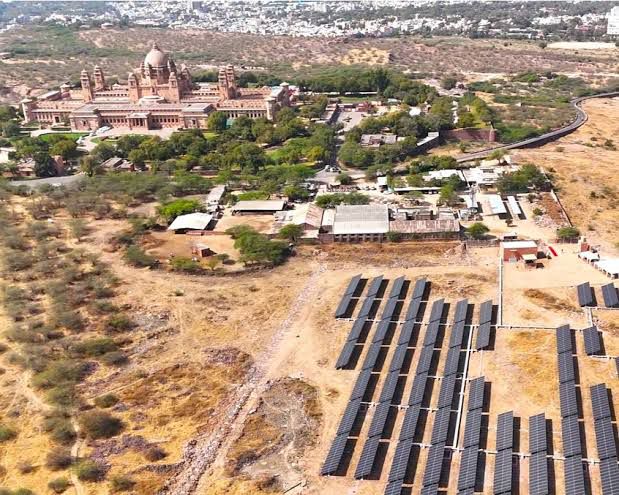 Aerial view of Umaid Bhawan Palace in Jodhpur with a ground-mounted solar array in the foreground